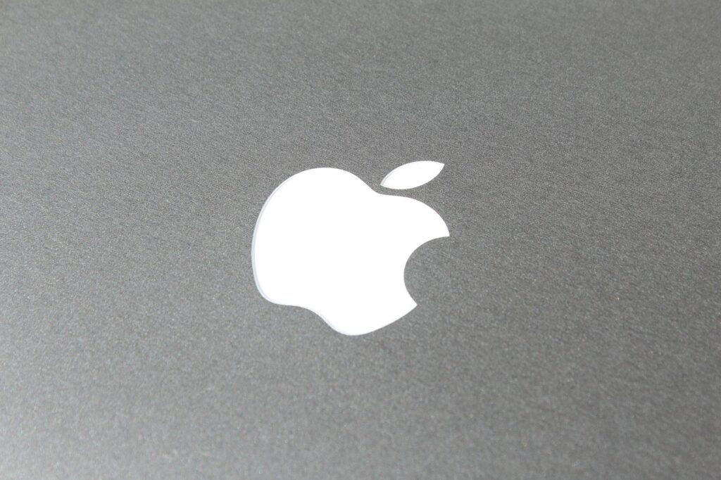 Profesjonalista pracujący na laptopie Apple MacBook Pro 16 na drewnianym biurku
